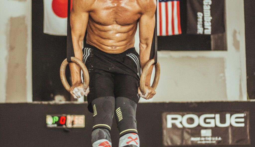 Male athlete performing ring muscle ups
